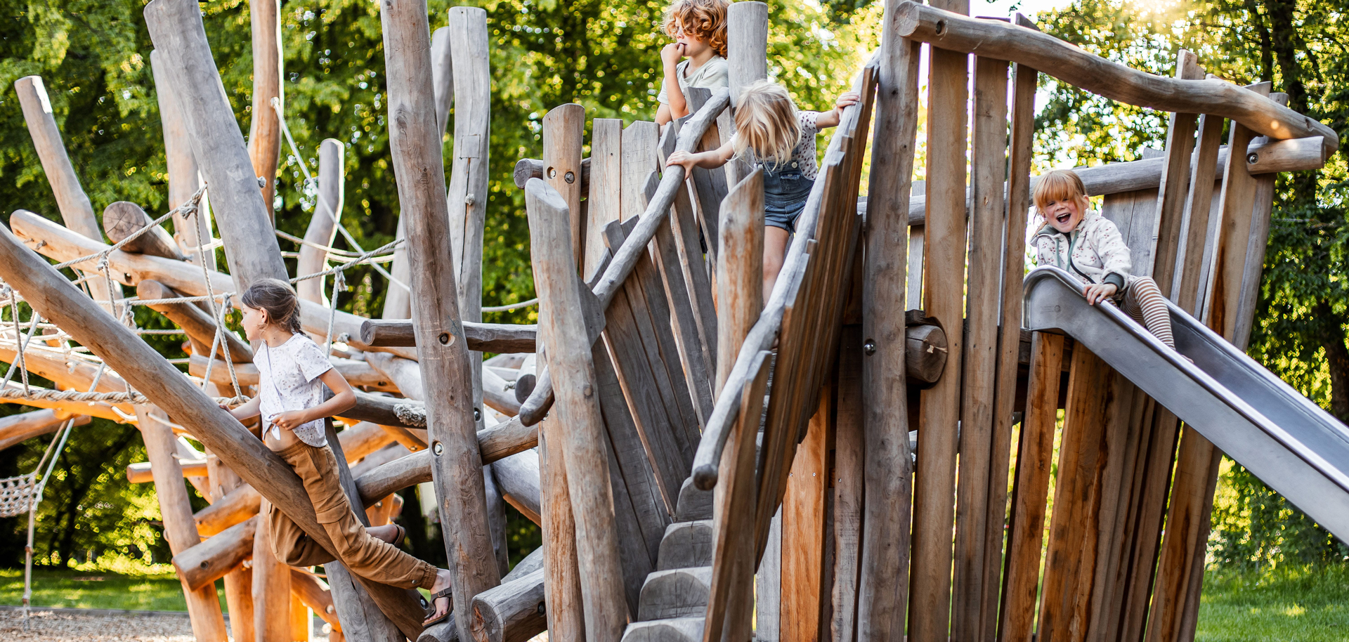 Spielende Kinder auf einem Klettergerüst aus Holz